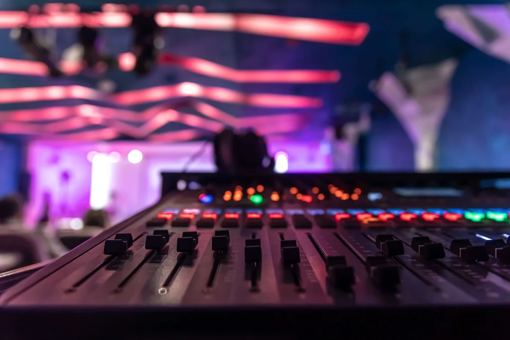 Sistema de sonido profesional con altavoces y mezclador en evento corporativo con técnico operando